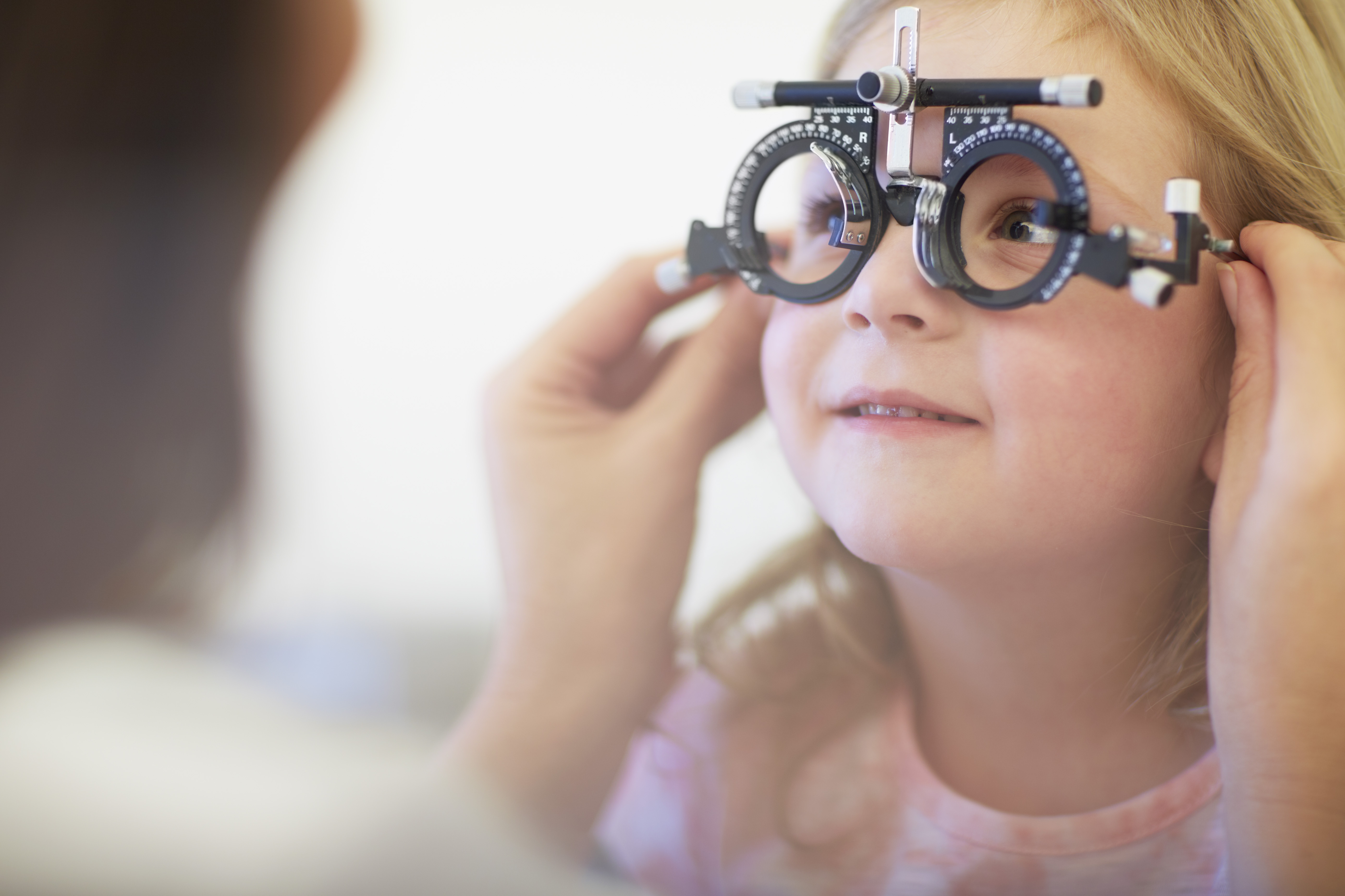 Gros plan de petite fille qui fait test oculaire chez ophtalmologue